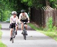 Two people riding bikes on a path.
